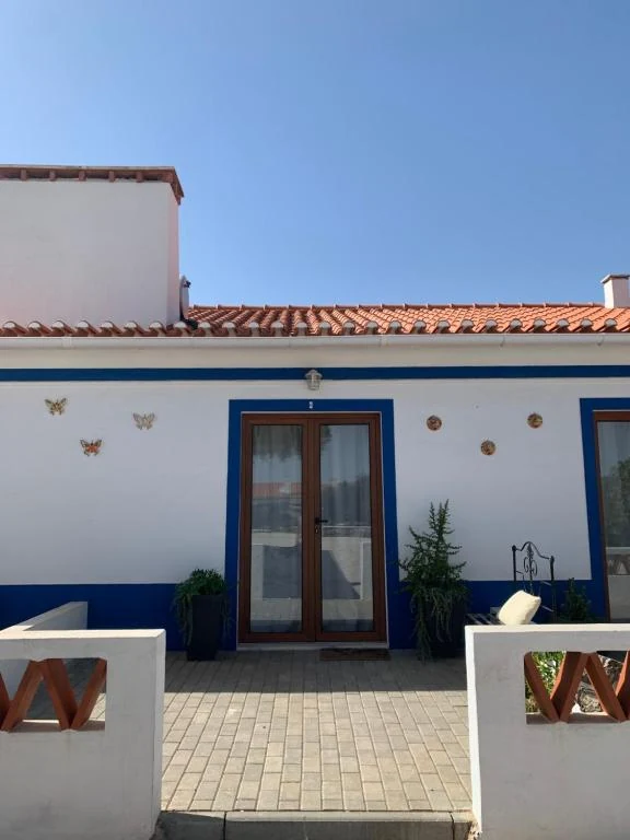 Whitewashed Herdade Da Maridona farmhouse with blue trim and a private patio